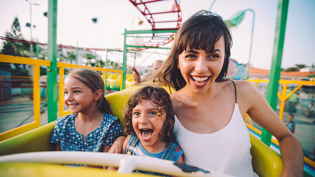 woman and kids riding rollercoaster